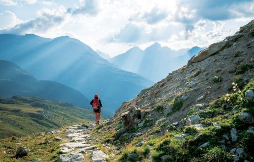 Hiker on trail in the mountains on a cloudy day