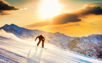 Snowboarding silhouette with orange sky and mountian in background
