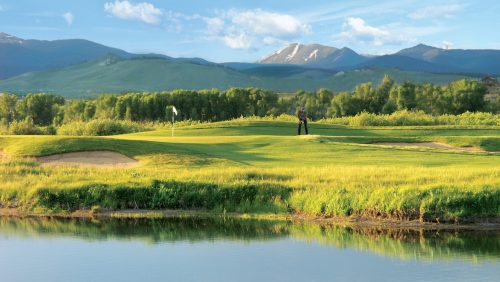 golf course view with water feature and mountain backdrop